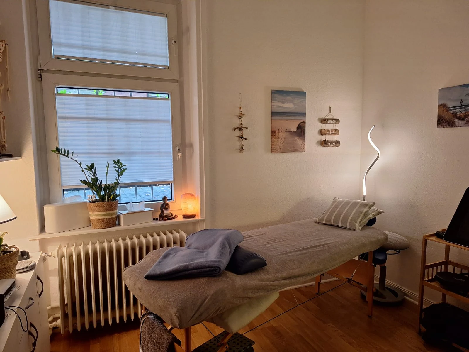 Behandlungsraum mit Behandlungsliege, Fenster und warmem Licht